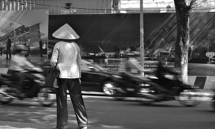 Ho Chi Minh Ville, mutations rapides, rêves de modernité, circulation dense. Sur le bord du trottoir, une femme hésite. Elle semble venir d’ailleurs, d’un monde ralenti, des campagnes vietnamiennes. Cliché : Pascal Clerc